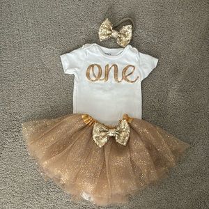 Great little “One” onesie with a gold tutu and bow